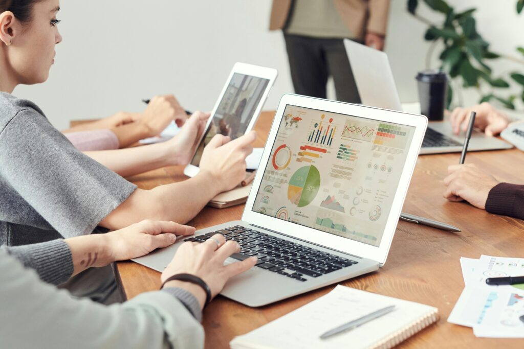A person working on a laptop displaying a data dashboard with charts and graphs